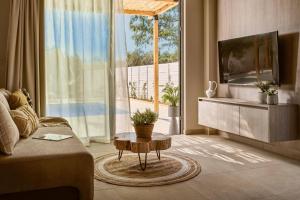 a living room with a couch and a tv at Villa Romas 3 by Villa Plus in Vasilikos