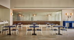 a restaurant with blue tables and white chairs at Chia Laguna - Hotel Village in Chia