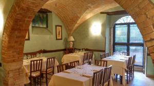 a dining room with white tables and chairs and a window at Hotel Turrita in Arrone