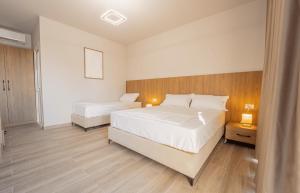 a bedroom with two beds and a wooden headboard at TIA Layover Rooms in Krujë