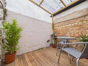 a patio with a table and chairs on a wooden deck at Kings Row in Cheltenham