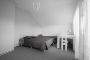 a bedroom with a bed and a desk and a table at Vėjo Malūnų sodyba - Didžioji vila in Paserninkai