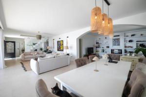 Una sala de estar con una mesa y sillas blancas. en Spacious Guesthouse with amazing Monaco & Sea View, en La Turbie