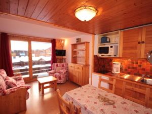 a kitchen and living room with a table in a room at Studio cabine lumineux avec balcon et vue, 4 pers, TV, Wi-Fi, Les Saisies - FR-1-293-142 in Les Saisies