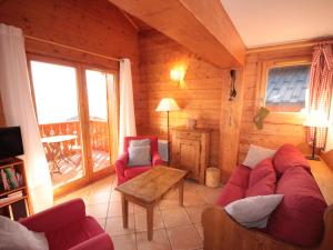 a living room with a red couch and a table at Appartement 4 pièces mezzanine avec balcon, équipements complets, animaux admis, parking couvert. - FR-1-293-64 in Villard-sur-Doron