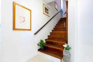 un escalier dans une maison avec des marches en bois et un tableau sur le mur dans l'établissement Villino D'Agostino - Locazione Turistica, à Francavilla al Mare