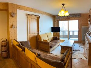 a living room with a couch and a tv at Appartement lumineux 8 pers avec piscine et parking près des pistes à Villard-sur-Doron - FR-1-293-363 in Villard-sur-Doron
