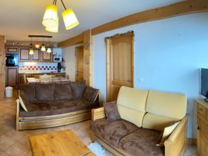 a living room with a couch and a table at Appartement lumineux 8 pers avec piscine et parking près des pistes à Villard-sur-Doron - FR-1-293-363 in Villard-sur-Doron