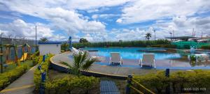 einen großen Pool mit Stühlen und Rutsche in der Unterkunft Apartamento con piscina cerca al parque del café in Montenegro