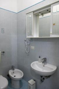 a bathroom with a sink and a toilet and a mirror at Casa Vacanza Gate Centro in Pisa +1 photo