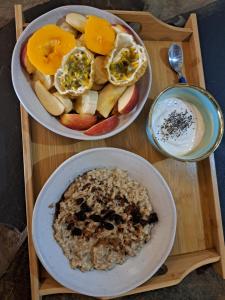 two plates of food with fruit and a bowl of yogurt at Diani Yoga Barn in Ukunda