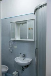 a bathroom with a sink and a mirror and a shower at Casa Vacanza Gate Centro in Pisa