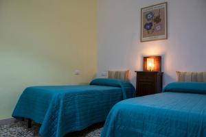 two beds in a room with blue sheets on them at Casa Vacanza Gate Centro in Pisa