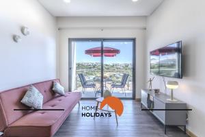 a living room with a couch and a table with chairs at #312 Ocean Outlook by Home Holidays in Páteo