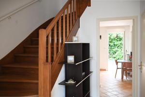 a staircase in a home with a wooden stair case at La Pause Royannaise - 500 m de la plage in Royan +6 photos