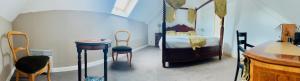 a bedroom with a bed and a table and chairs at Relais Guinguette in Tinténiac