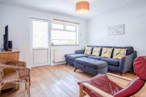 a living room with a couch and a tv at Cosy Cottage - 2 Bedroom Cottage - Mumbles in Swansea