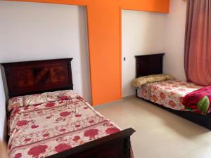two beds in a room with orange walls at Family holiday home beach view in Alexandria