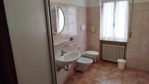 a bathroom with a sink and a toilet and a mirror at Locanda Antica Bribano in Sedico