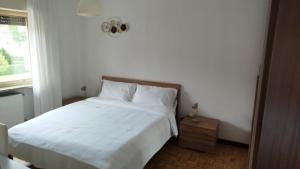 a bedroom with a white bed and a window at Locanda Antica Bribano in Sedico
