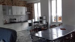 a kitchen with a table and chairs in a room at Simadline in Sartilly