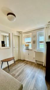 シュタット・ヴェーレンにあるKleines Natursteinapartment 4 für 1 Personのリビングルーム(テーブル、窓2つ付)