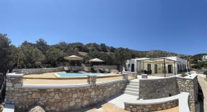 加利萨斯Caldera Suites "Φάρος"的一座别墅的形象,别墅内设有游泳池和石墙