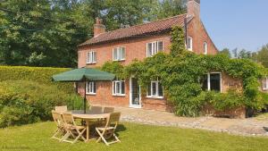 un tavolo e delle sedie davanti a una casa di Wherry Cottage in Irstead on the Norfolk Broads a Neatishead