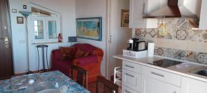 a kitchen with a sink and a couch in a room at Buena Vista in SantʼAntìoco