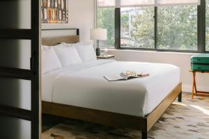 una camera da letto con un letto con un libro sopra di Sonder by Marriott Bonvoy Georgetown C&O Apartments Georgetown a Washington