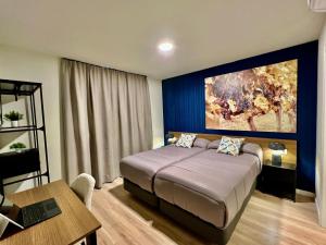 a bedroom with a bed with a large painting on the wall at Iraipe Haro Auto Check-in in Haro