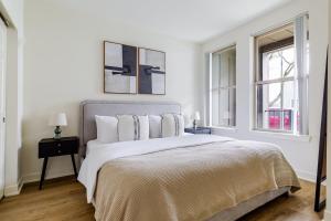 ein weißes Schlafzimmer mit einem Bett und zwei Fenstern in der Unterkunft Blueground NW Bellevue gym bbq nr park SEA-848 in Seattle