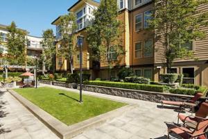 ein Innenhof mit Stühlen und einer Wiese vor einem Gebäude in der Unterkunft Blueground NW Bellevue gym bbq nr park SEA-848 in Seattle