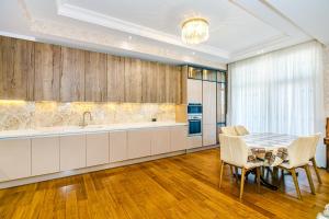 Una cocina con una mesa y sillas y un fregadero. en Luxury Apartments on Centre, en Baku