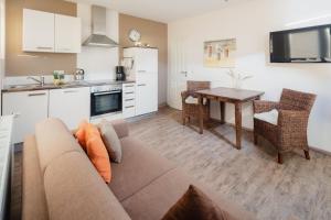 a living room and kitchen with a couch and a table at Haus Juistine Süd in Juist