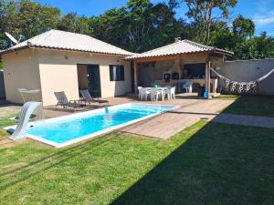 a backyard with a swimming pool and a house at Chalé da Márcia com Piscina e Churrasqueira Privativos in Buzios