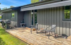 哈尔姆斯塔德Nice Home In Halmstad With Wifi的房屋内带椅子和烧烤架的甲板