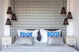 a bedroom with a bed with blue and white pillows at Azur Villa in Balatonalmádi