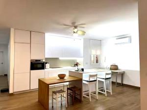 a kitchen with white cabinets and a table and chairs at Céntrico Apartamento en Jaén 107 m2 2 baños 4 pax in Jaén +6 photos