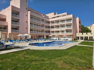 a large building with a swimming pool in front of it at Monte Treasure - Beach, Wifi, Pool, Parking in Monte Gordo