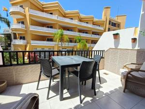 a table and chairs on a balcony with a building at Cozy Ocean Park in Adeje