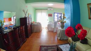 - un salon avec un canapé et une table ornée de fleurs rouges dans l'établissement Rosa Di Mare, à San Ferdinando