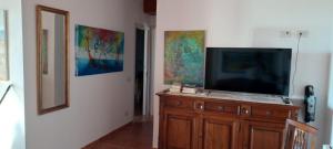 a television on a wooden dresser in a room at Buena Vista in SantʼAntìoco