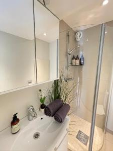 a white bathroom with a shower and a sink at Harmony Apartments - By Honivi Gruppen in Stavanger +13 photos