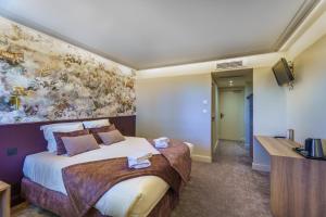 Postel nebo postele na pokoji v ubytování Hôtel Le Clos des Arts