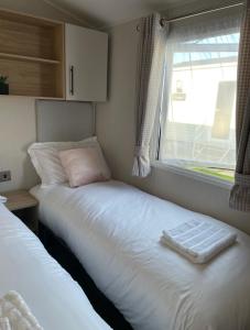 a small bedroom with a bed and a window at Willerby lamberhurst in Westgate on Sea