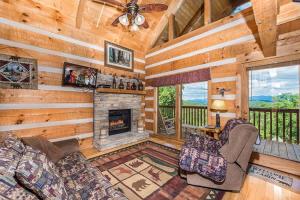 a living room with a fireplace in a log cabin at View! Private! Hot Tub,Pool Table,Fireplace,RELAX! in Sevierville