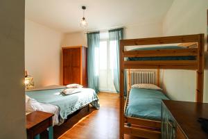 a bedroom with two bunk beds and a kitchen at Domus Angularia in Anguillara Sabazia