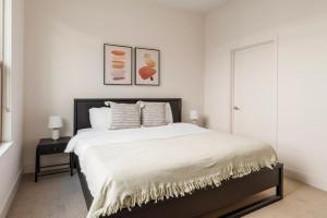 een slaapkamer met een groot bed met witte lakens bij Blueground Menlo Park pool nr Baylands Park SFO-1287 in San Francisco +30 foto's