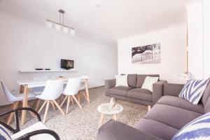 a living room with a couch and a table at Apartamentos Bahia in Santa Eularia des Riu